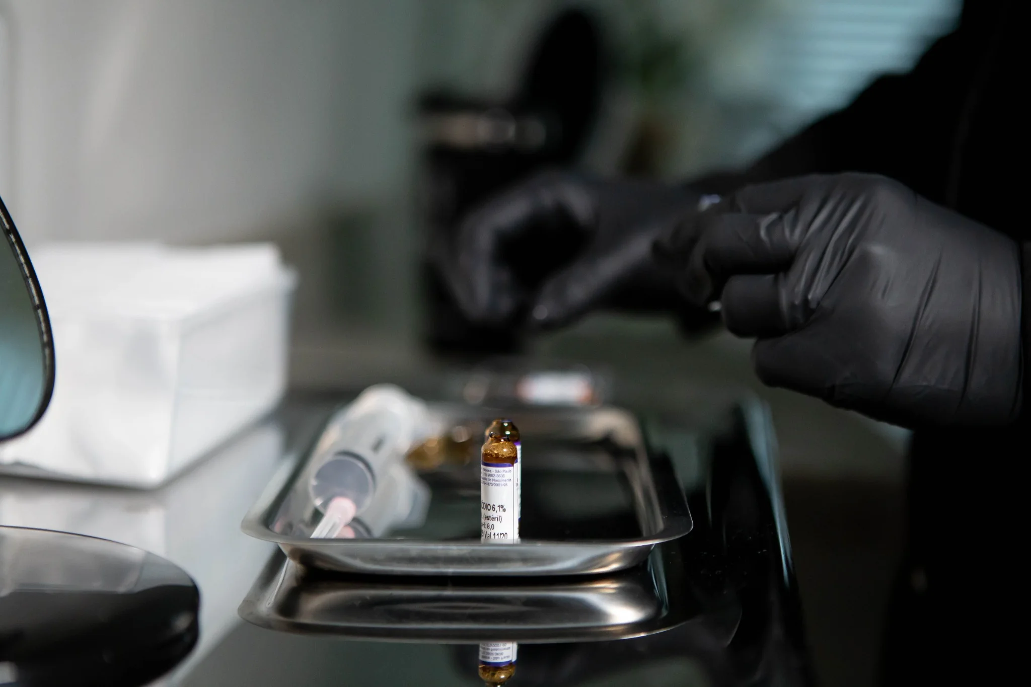 Materiais clínicos genéricos, com frasco e seringa sobre bandeja metálica; a foto não documenta procedimento de Mesoterapia.